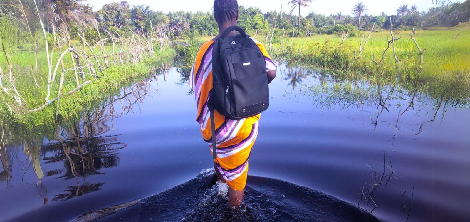 A BOHEMIA project fieldworker walking on a flooded street